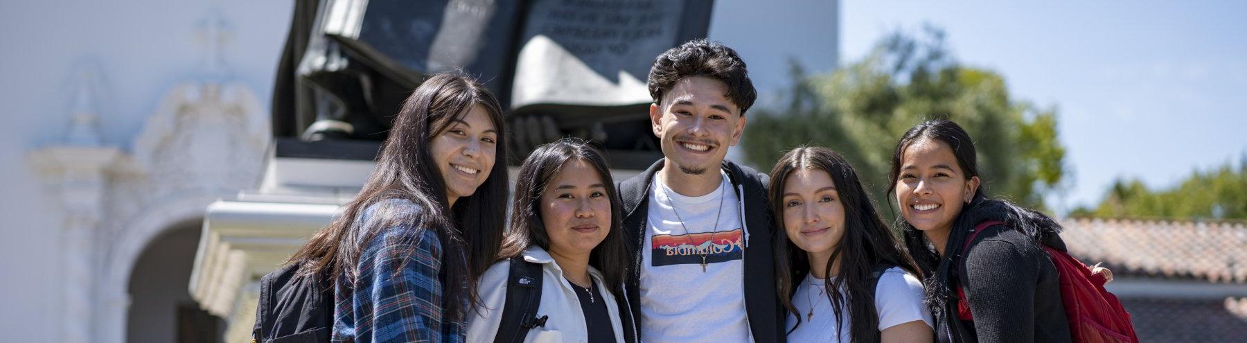 group of students with backpacks standing together and smiling on the first day of school